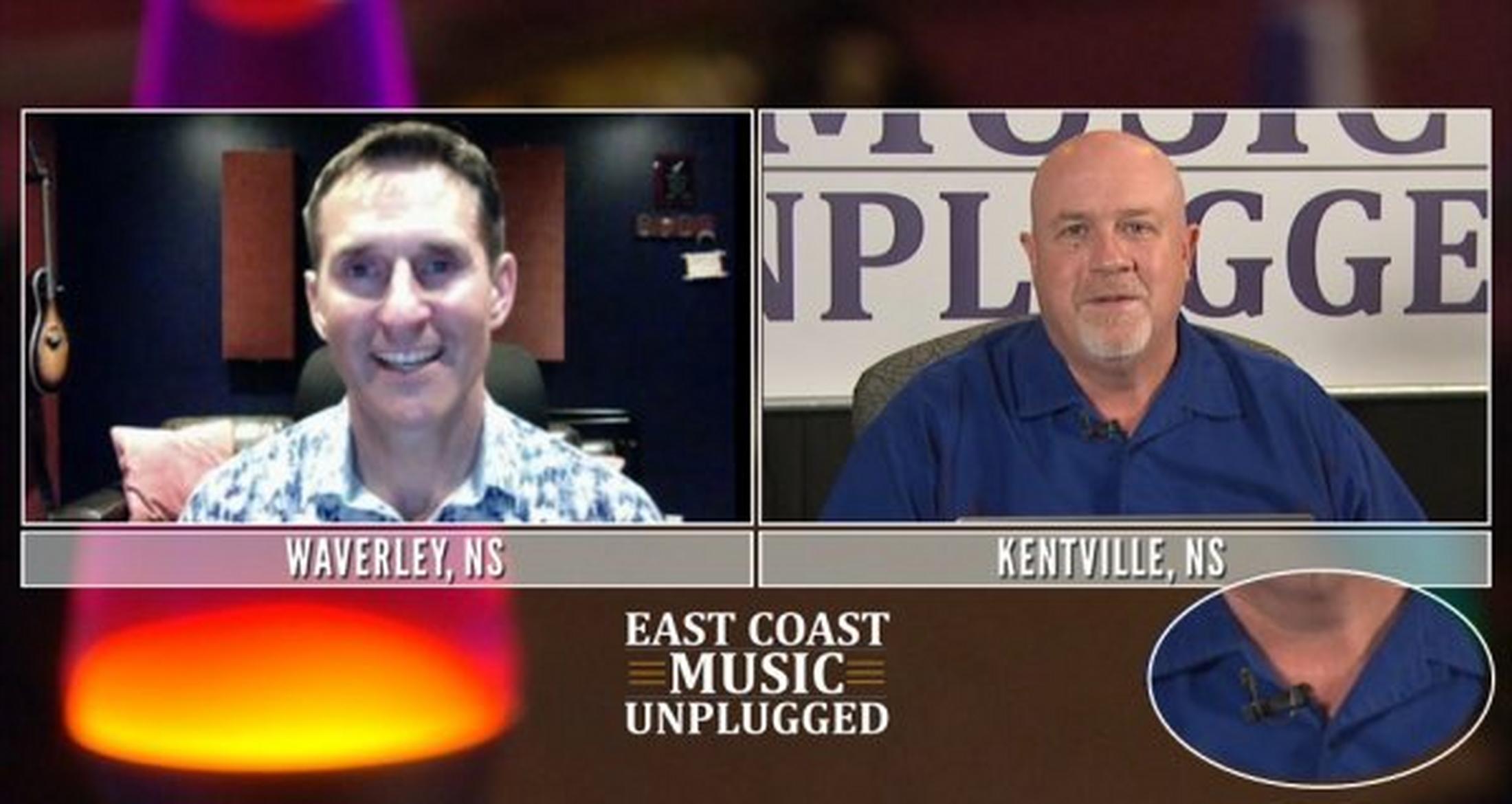 two men are sitting in front of a microphone and one of them is wearing a blue shirt